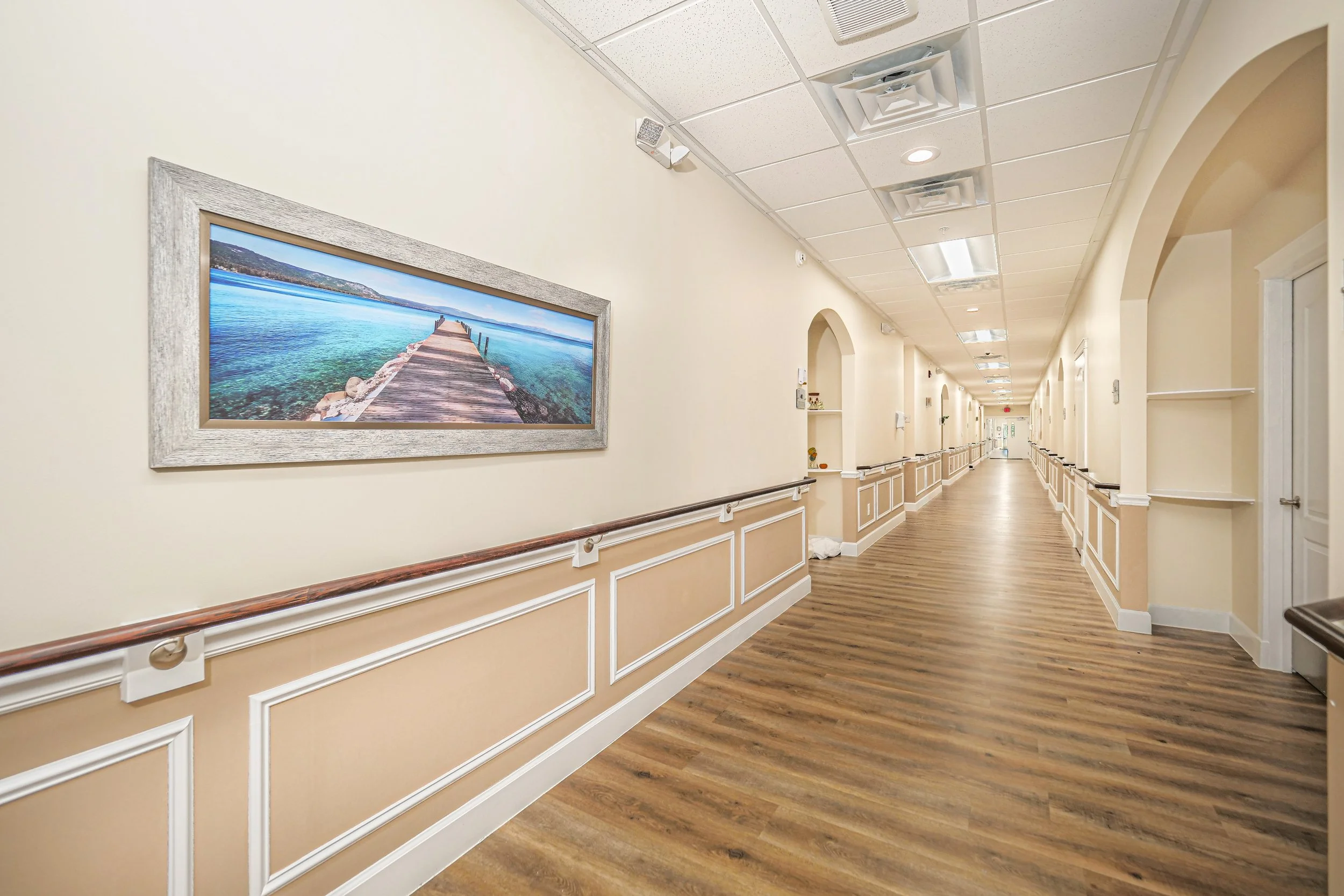 A hallway with a serene ocean-themed artwork.