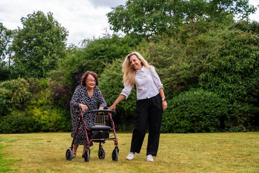 A caregiver assisting a resident outdoors.
