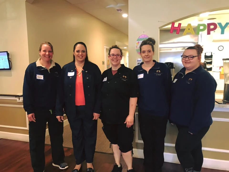 Staff members smiling in a common area