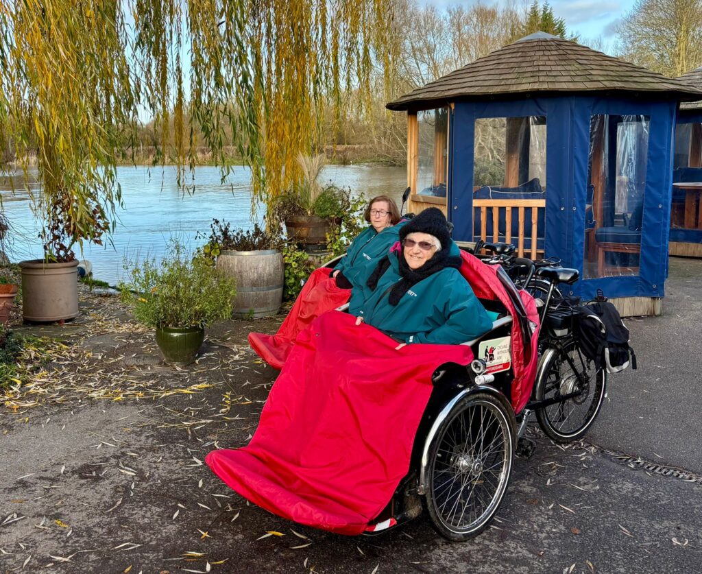 Residents enjoying a ride in a tricycle by the waterfront.