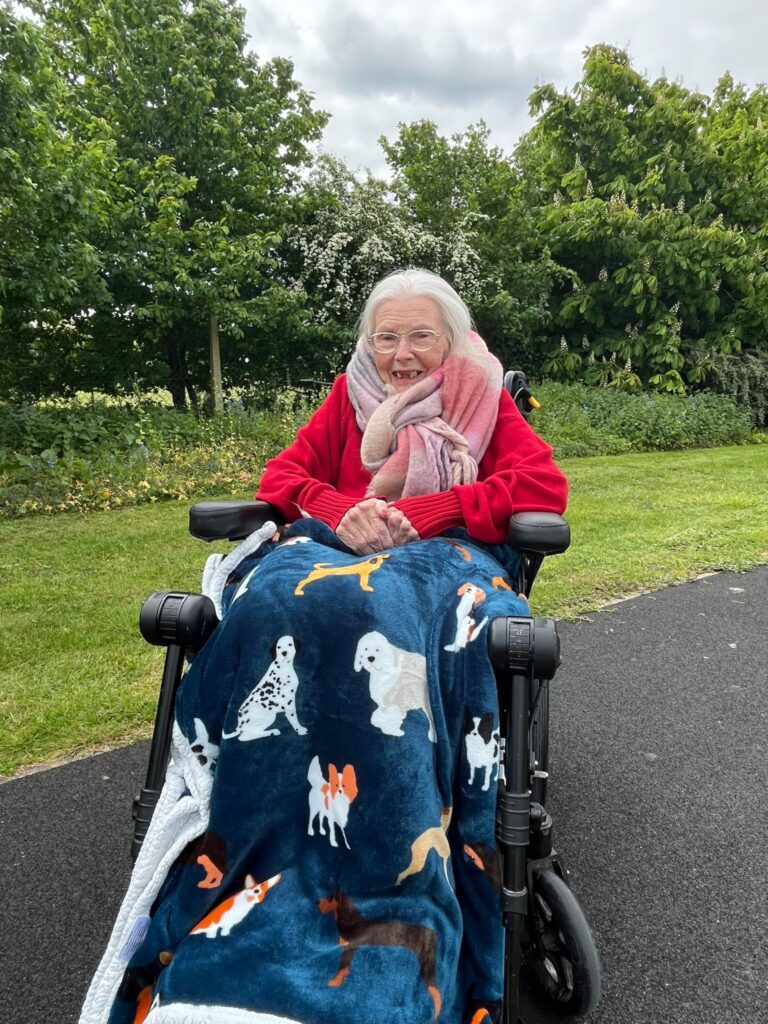 Resident enjoying outdoors in a wheelchair.
