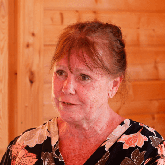 Smiling woman with red hair in floral attire