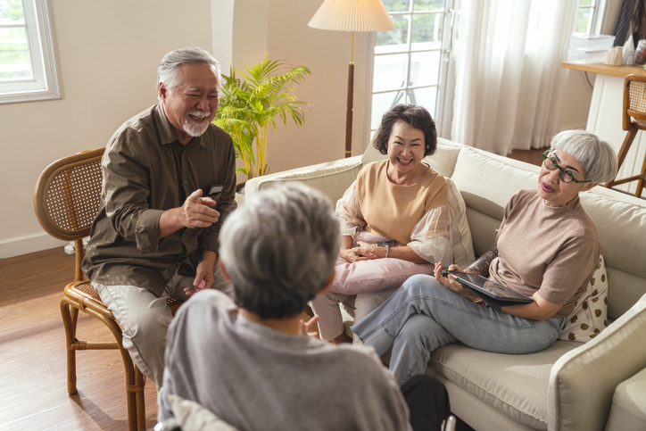 Seniors engaged in conversation in a cozy setting.