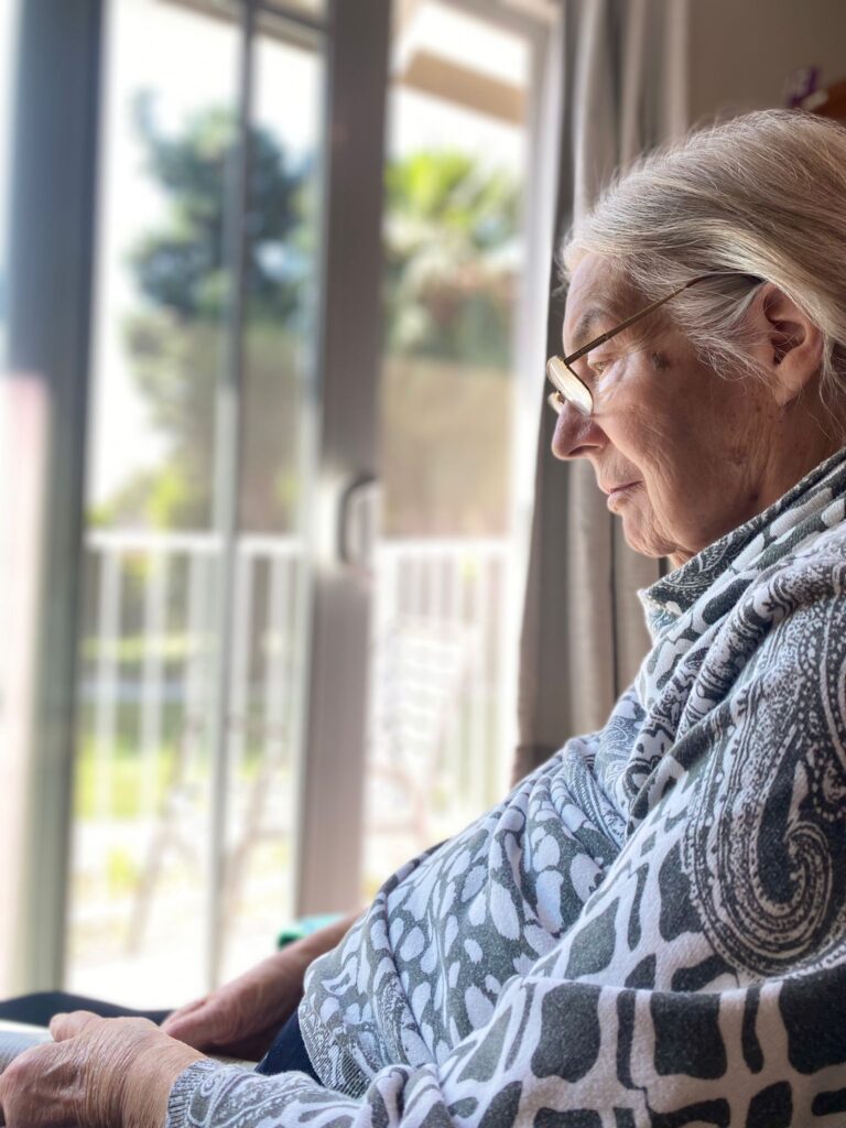 Senior woman reading quietly indoors.