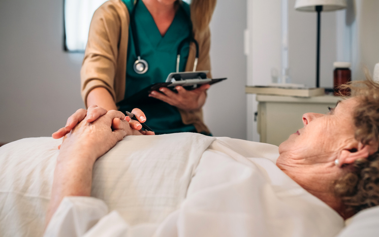 A caregiver attending to a resident in bed.