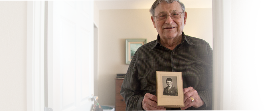 Senior man holding a vintage photograph in a room