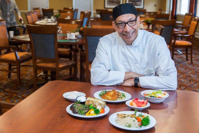 Chef presenting various meals in the dining room