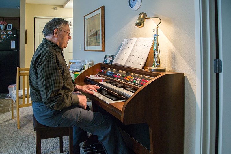 Resident playing the organ in a cozy room