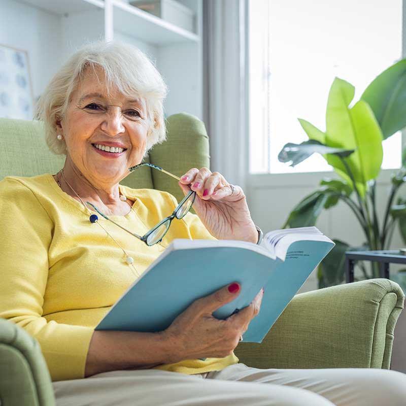 A senior woman enjoying a book in a cozy chair