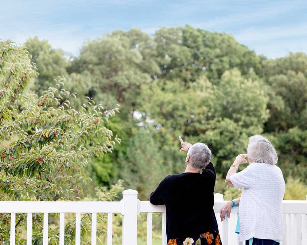Two residents enjoying the outdoors, pointing at trees
