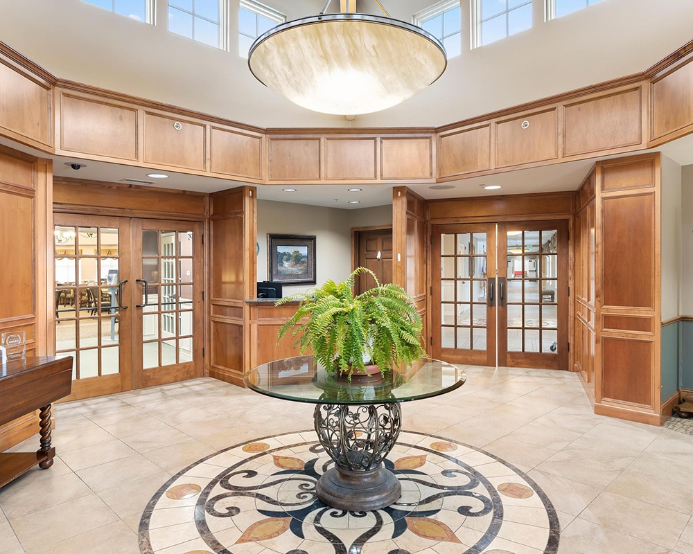 Bright lobby area of a senior living facility with a plant