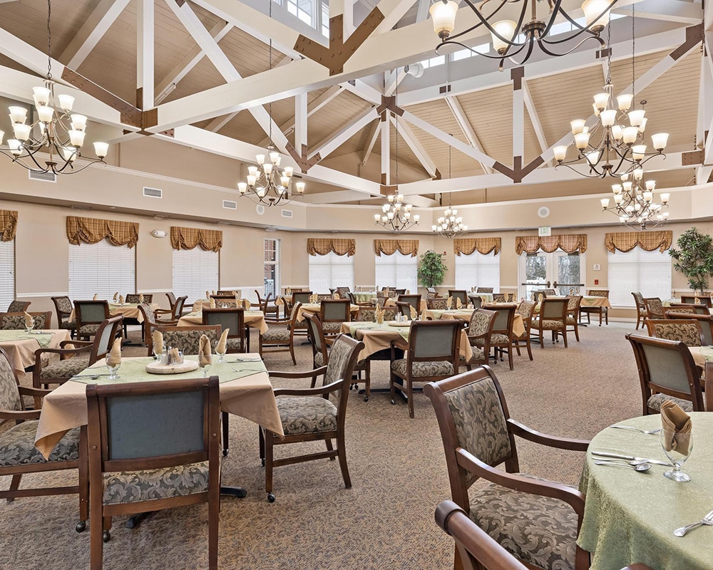 Elegant dining room setup with large windows and chandeliers