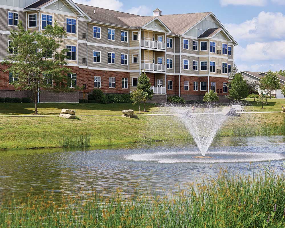 Exterior view of Luther Oaks with a pond and fountain