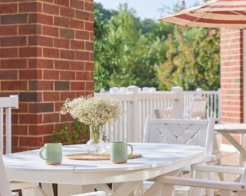 Outdoor seating area with flowers and coffee mugs