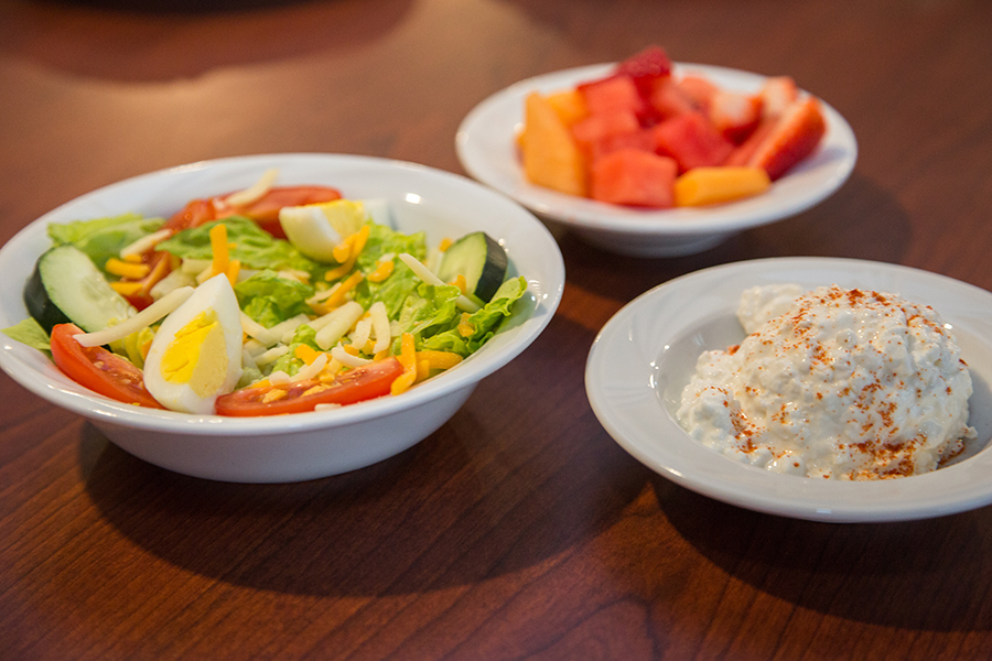 Bowls of salad and fresh fruit on a table