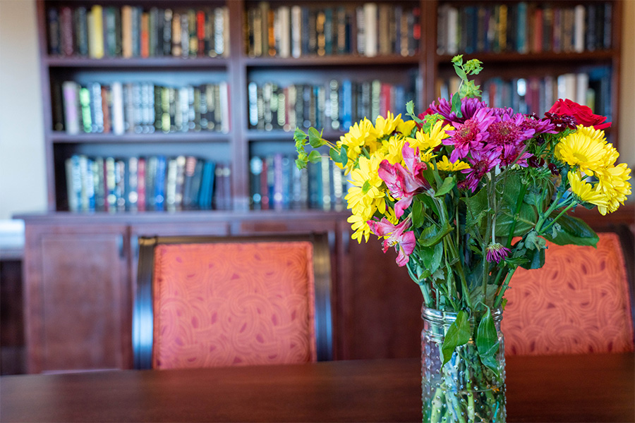 A vibrant bouquet of flowers on a table in a library