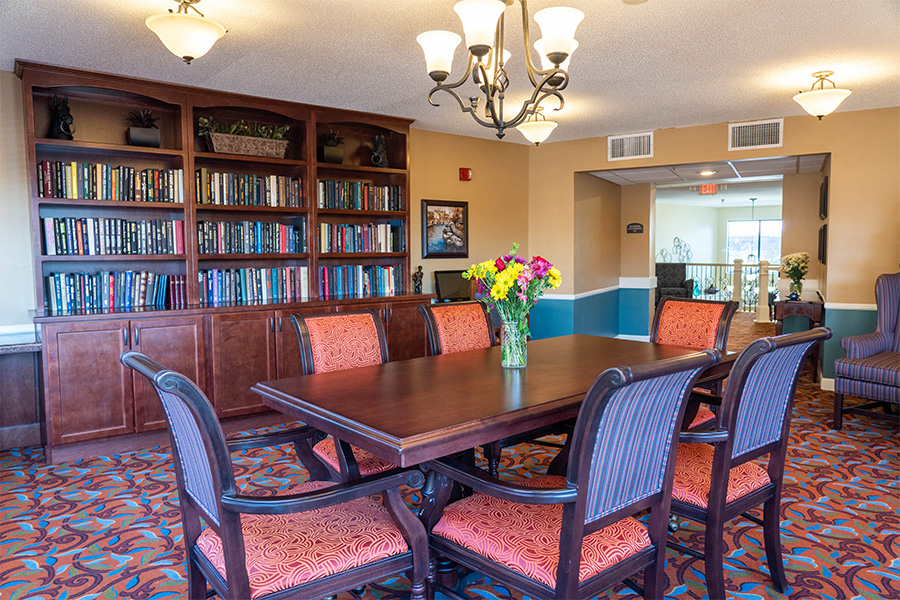 Bright common area with a dining table and bookshelves