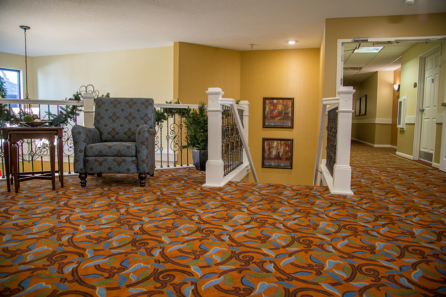 Decorative corridor area with carpet and chair