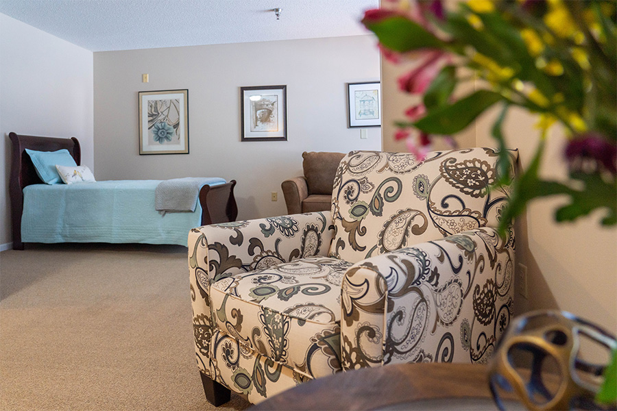 Cozy resident room with decorative chair and bed
