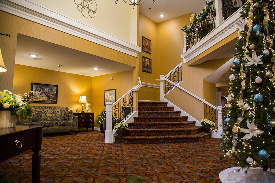 Interior lobby area with decorated staircase and Christmas tree