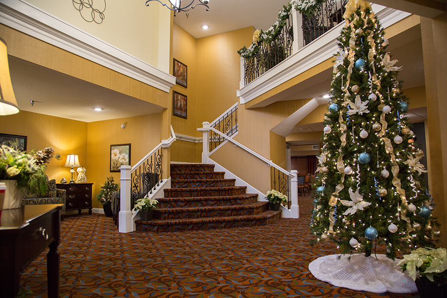 Interior view of a decorated lobby with a staircase and Christmas tree