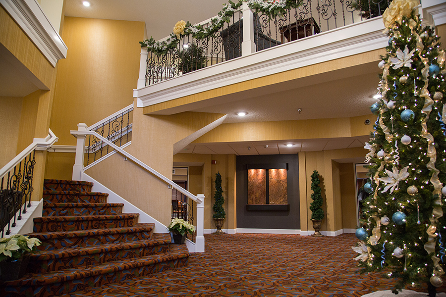 Interior view of a decorated lobby with a staircase and Christmas tree