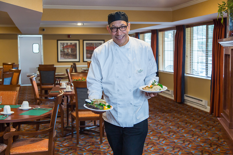 Staff member serving meals in the dining room