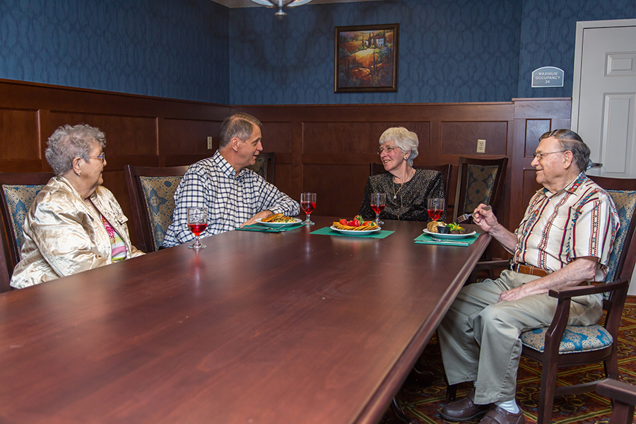 Residents enjoying a meal together in a dining room.