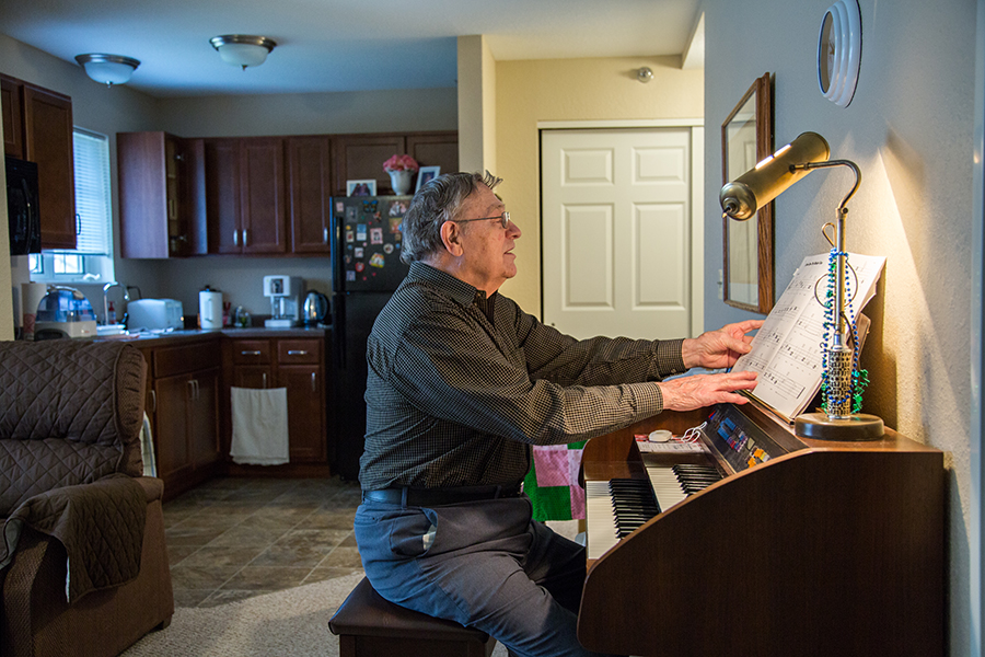 A resident playing piano in a cozy living space