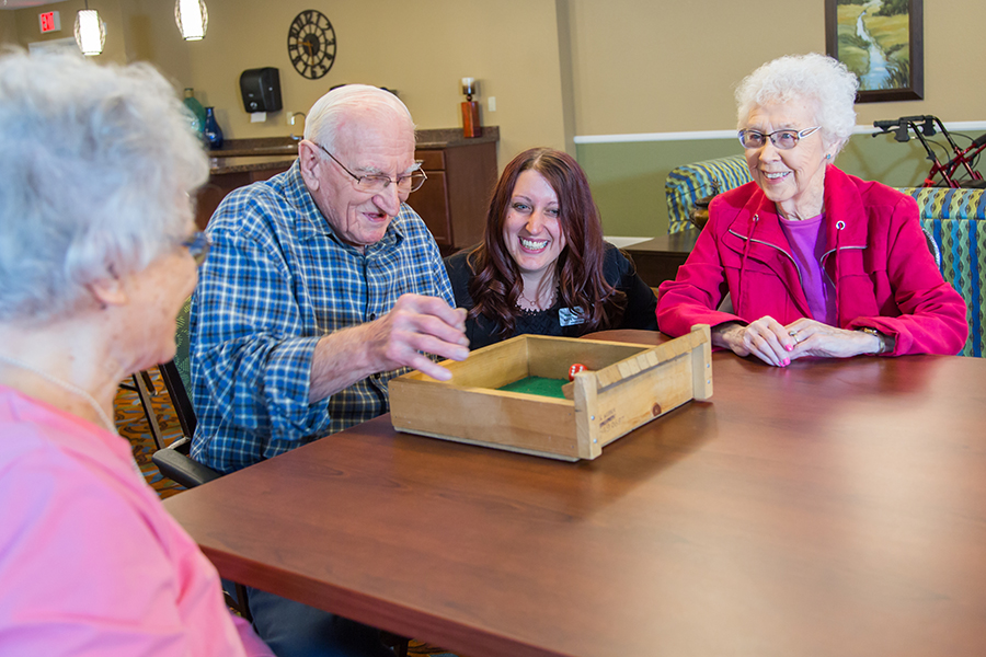 Residents enjoying a game with staff in a common area