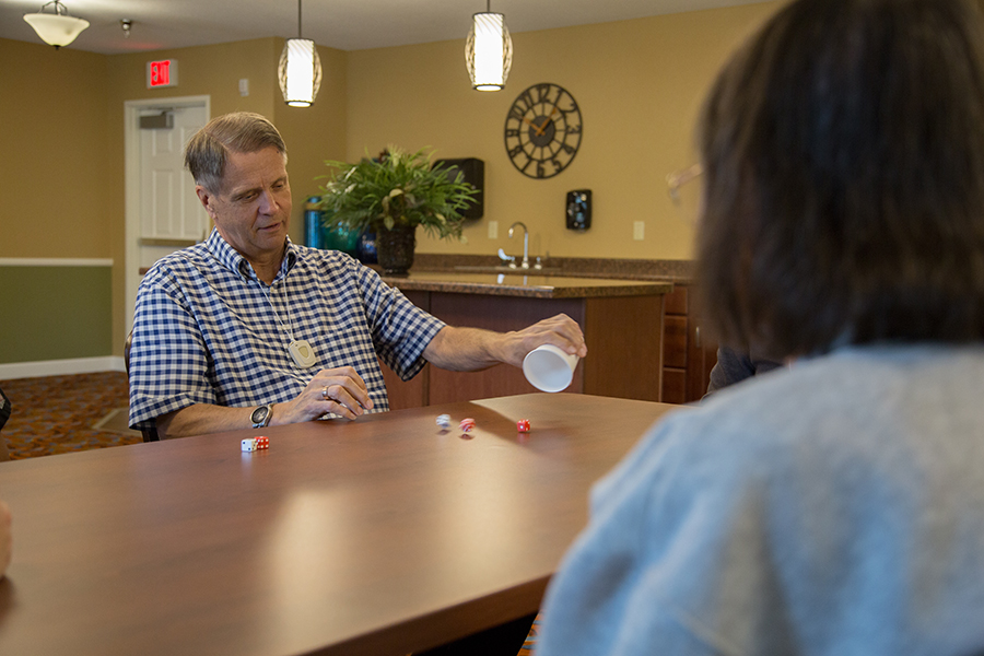 Residents engaging in a dice game in a common room