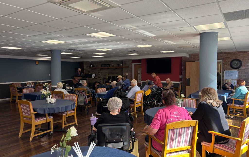 Residents enjoying a musical performance in a common area.