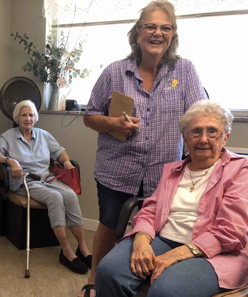 Two residents and staff member in a common area.