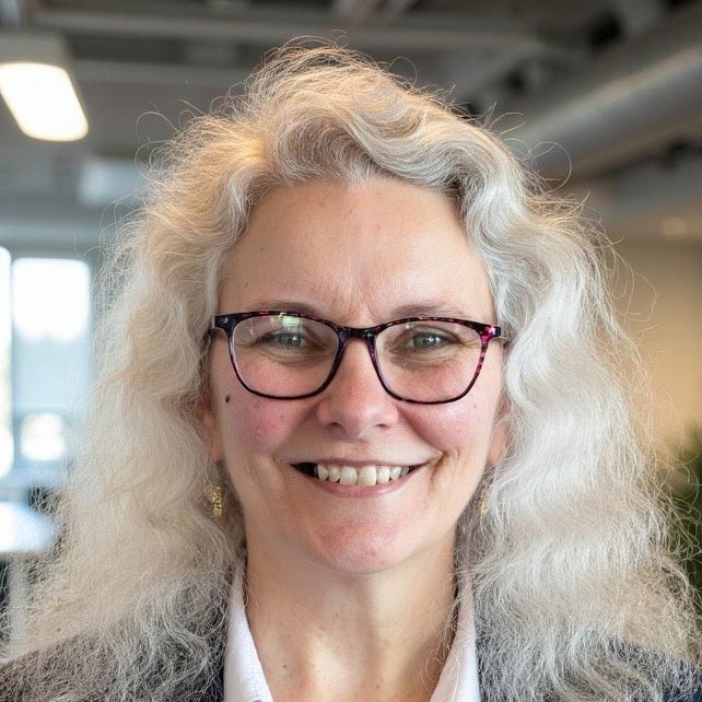 Senior staff member smiling in an office setting.