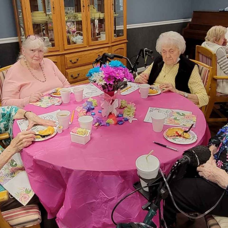 Residents enjoying a meal together at a festive table.