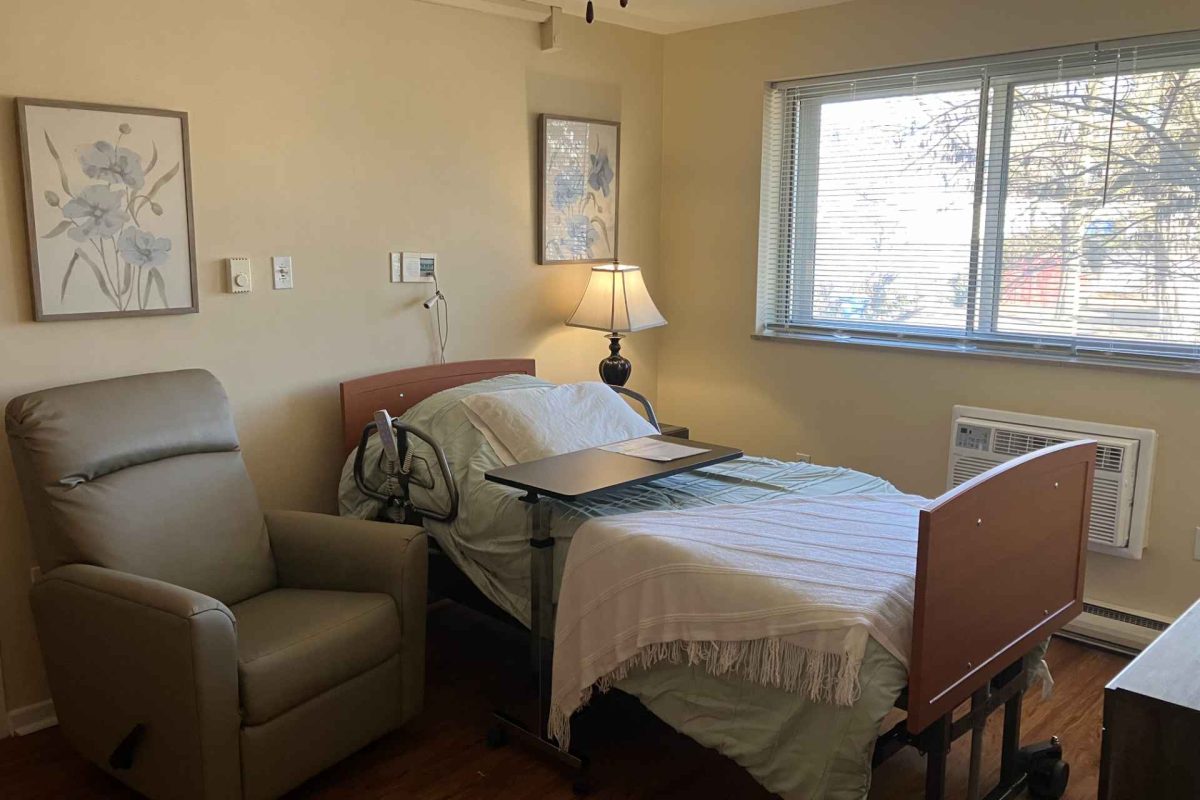 Well-furnished resident room with a bed and chair.