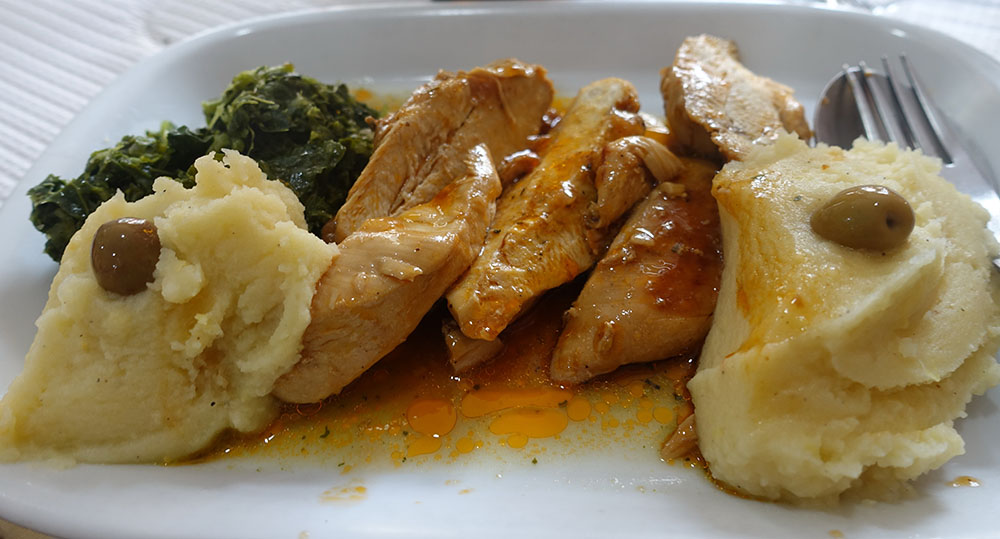 Plate of chicken, greens, and mashed potatoes
