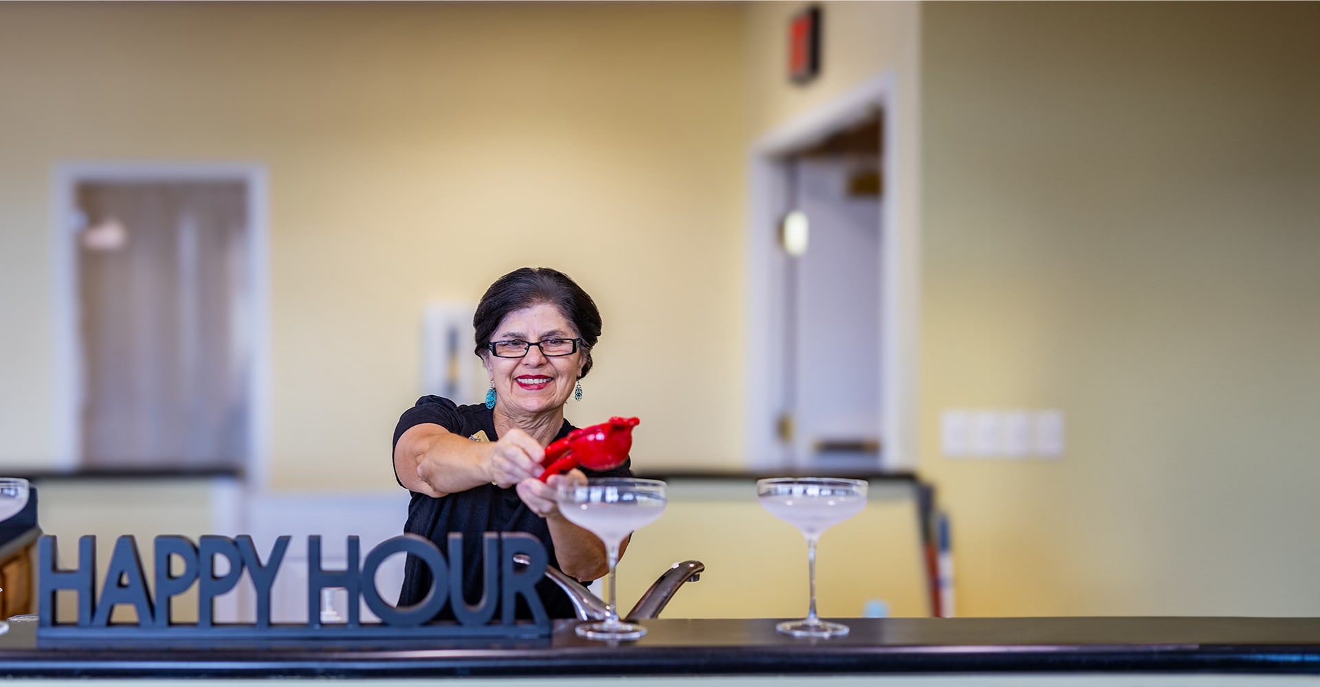 A staff member serving drinks during happy hour