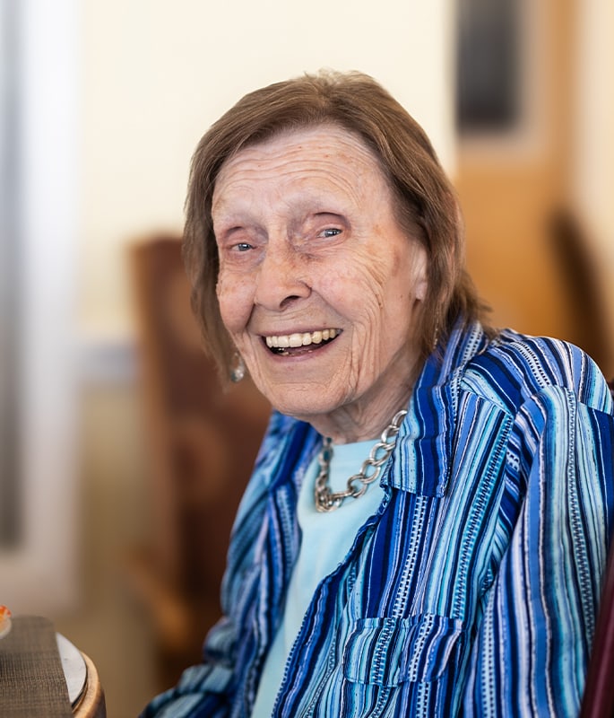 A smiling resident enjoying company in a common area