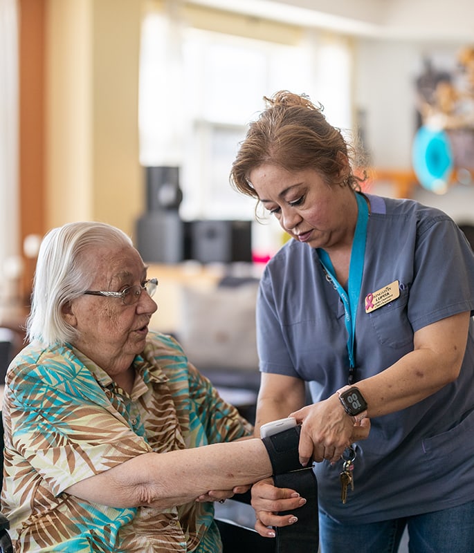 A caregiver taking a resident's blood pressure