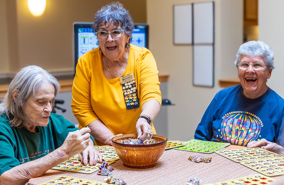 Residents engaging in a bingo game with staff assistance