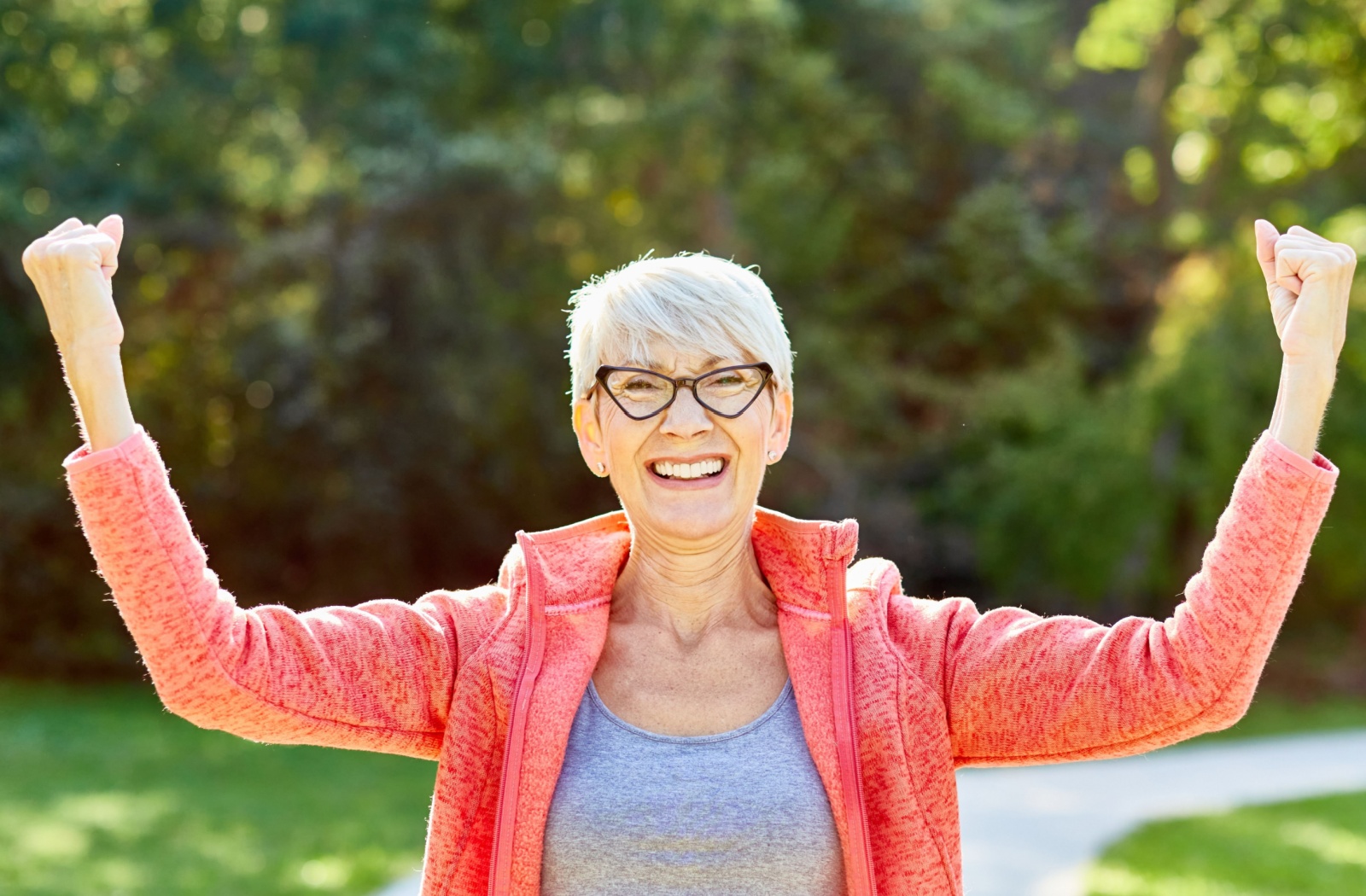 Smiling senior woman celebrating outdoors