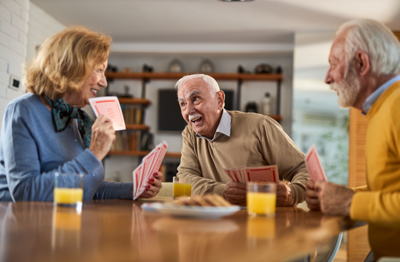 Seniors playing cards and enjoying refreshments at a table