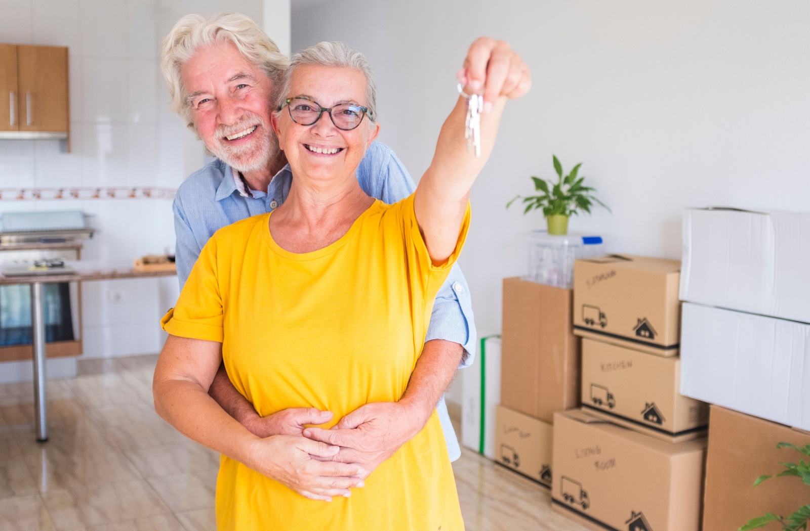 Happy elderly couple celebrating a new home.
