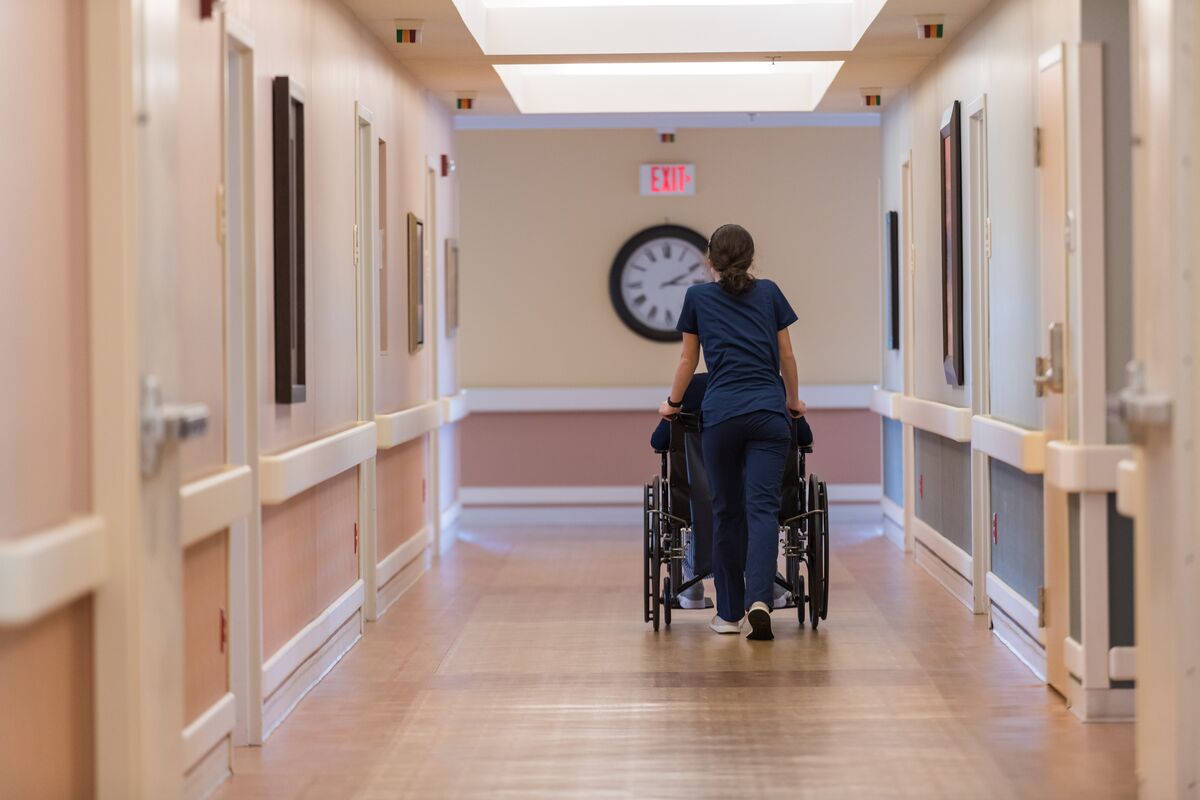 Staff member pushing a resident in a hallway