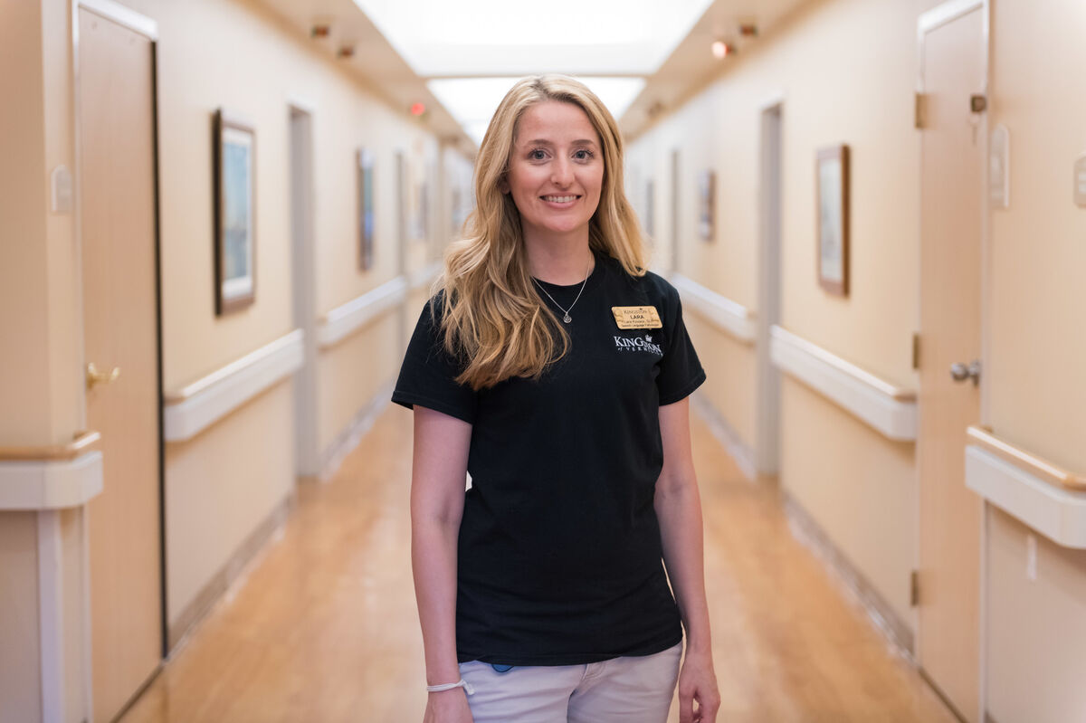 Staff member standing in a well-lit hallway