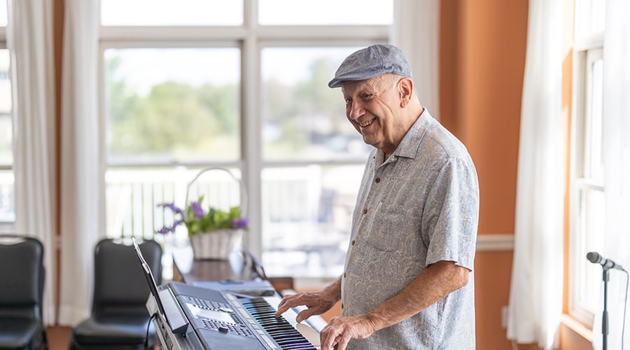 Resident playing keyboard in a bright activity room