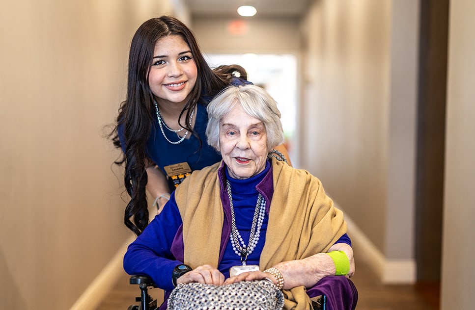 A staff member assisting a resident in a hallway