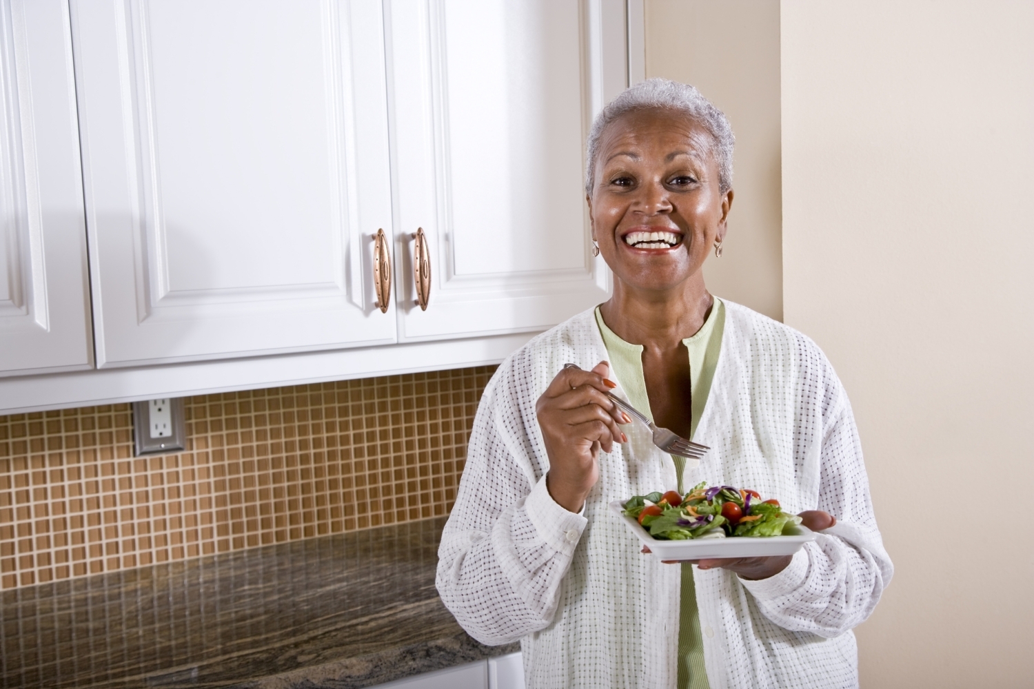 Smiling senior woman enjoying a healthy salad