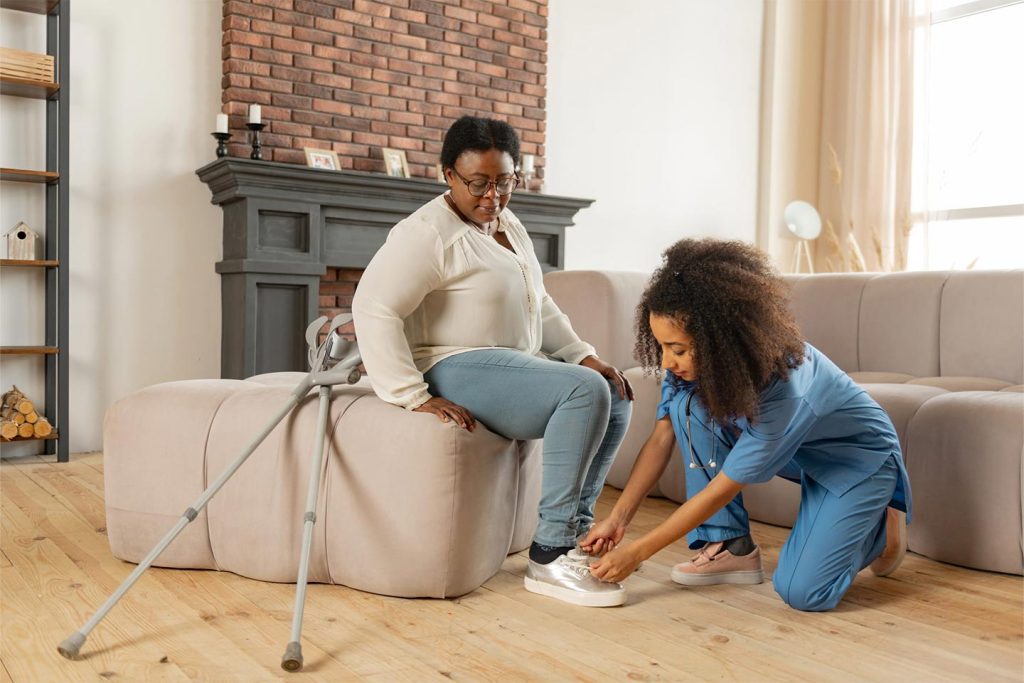Caregiver assisting resident with shoes.